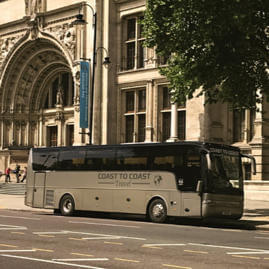 Side view of a Coast to Coast Travel coach parked outside a museum in London